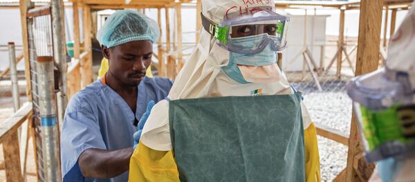In this photo taken on Monday, March 2, 2015, a health care worker prepares a colleague's virus protective gear before entering a high risk zone at an Ebola virus clinic operated by the International Medical Corps in Makeni, Sierra Leone In this photo taken on Monday, March 2, 2015, a health care worker prepares a colleague's virus protective gear before entering a high risk zone at an Ebola virus clinic operated by the International Medical Corps in Makeni, Sierra Leone - Sputnik International