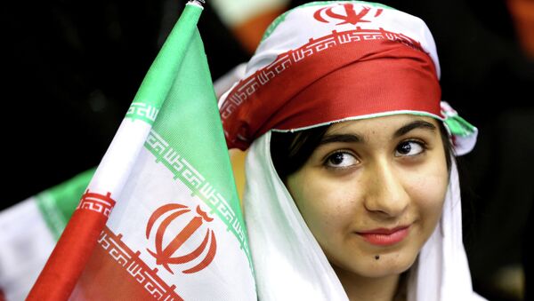 Iranian woman holds an Iranian flag during a ceremony - Sputnik International