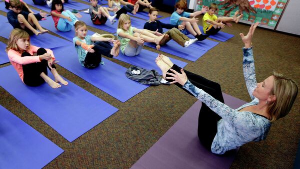 In this Dec. 11, 2012 file photo, Yoga instructor Kristen McCloskey, right, leads a class of third graders at Olivenhain Pioneer Elementary School in Encinitas, Calif. - Sputnik International