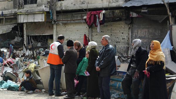 Residents wait to receive humanitarian aid at the Palestinian refugee camp of Yarmouk, in Damascus March 11, 2015 - Sputnik International