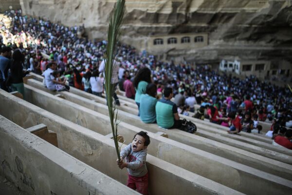 A boy waves a palm frond as Orthodox Christians celebrate Palm Sunday during a service in the Samaan el-Kharaz Church in the Mokattam district of Cairo, Egypt, Sunday, April 5, 2015. - Sputnik International