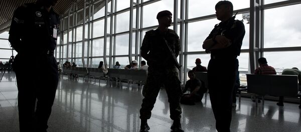 A member of the Malaysian Army (C) and a Malaysian policemen are silhouetted as they stand guard at Kuala Lumpur International Airport (KLIA) in Sepang, outside Kuala Lumpur on March 16, 2014 - Sputnik International