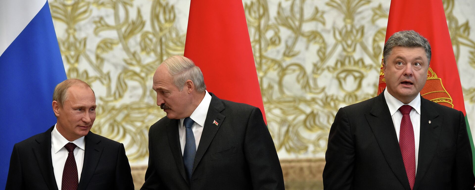 Belarus' President Alexander Lukashenko (C) gestures next to Russia's President Vladimir Putin (L) and Ukraine's President Petro Poroshenko as they meet in the Belarussian capital Minsk  - Sputnik International, 1920, 31.01.2023