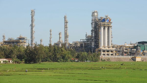 Vietnam's first oil refinery at Dung Quat looms over a rice field on February 22, 2009 in the central province of Quang Ngai - Sputnik International