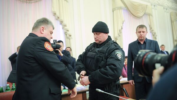A policeman puts handcuffs on the chief of Ukraine’s state service for emergency situations, Serhiy Bochkovsky, left, during the Cabinet session in Kiev, Ukraine, Wednesday, March 25, 2015 - Sputnik International