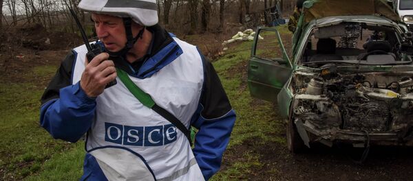 OSCE observers inspect a damaged car near Shyrokyne village, eastern Ukraine, Monday, March 30, 2015 OSCE observers inspect a damaged car near Shyrokyne village, eastern Ukraine, Monday, March 30, 2015 - Sputnik International