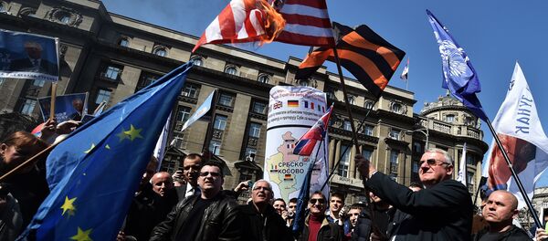 Serbian nationalist politician Vojislav Seselj (2nd R) holds a burning US flag flanked by supporters during an anti-government rally in Belgrade on March 24, 2015 - Sputnik International
