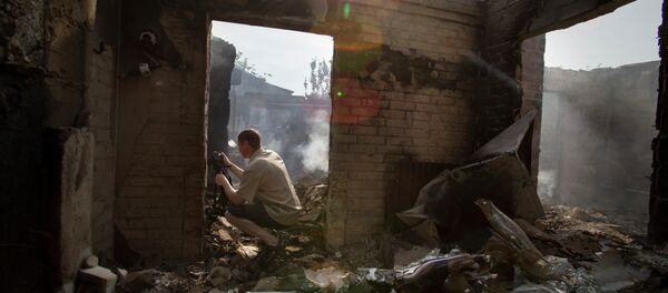 A journalist films a destroyed house following a mortar attack in Semyonovka village, outside Slavyansk, Ukraine, Friday, May 23, 2014 - Sputnik International