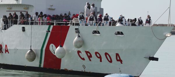 In this Wednesday, March 4, 2015, file photo, rescued migrants wait to disembark from an Italian Coast Guard vessel in Porto Empedocle, Sicily, southern Italy In this Wednesday, March 4, 2015, file photo, rescued migrants wait to disembark from an Italian Coast Guard vessel in Porto Empedocle, Sicily, southern Italy - Sputnik International