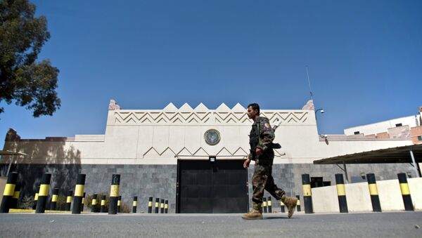 A Houthi fighter wearing an army uniform, walks past the gate of the main entrance of the US embassy after Yemeni police opened the road in front of it in Sanaa, Yemen, Wednesday, March 4, 2015 - Sputnik International