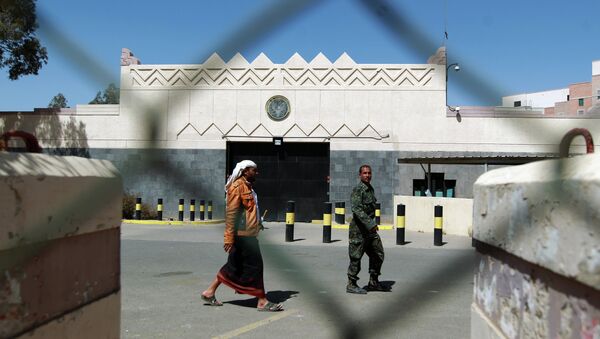 Yemeni men walk past the compound of the US embassy in Sanaa on March 4, 2015 - Sputnik International