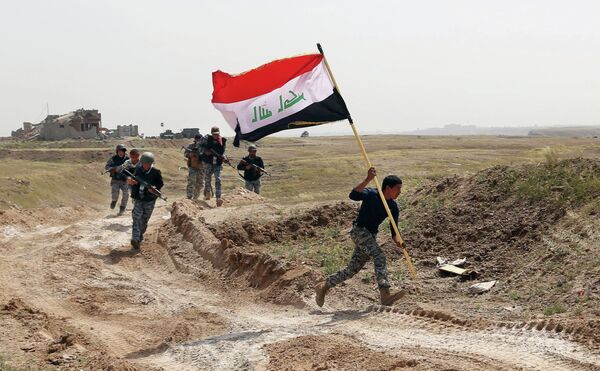 Member of the Iraqi security forces running to plant the national flag as they surround Tikrit during clashes to regain the city from Islamic State militants. Member of the Iraqi security forces running to plant the national flag as they surround Tikrit during clashes to regain the city from Islamic State militants. - Sputnik International
