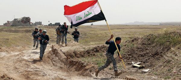 Member of the Iraqi security forces running to plant the national flag as they surround Tikrit during clashes to regain the city from Islamic State militants. Member of the Iraqi security forces running to plant the national flag as they surround Tikrit during clashes to regain the city from Islamic State militants. - Sputnik International