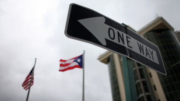 In this May 4, 2012 photo, the flags of Puerto Rico and the U.S. wave behind an English one-way traffic sign in Guaynabo, Puerto Rico, one of only a few places in Puerto Rico with street signs in English - Sputnik International