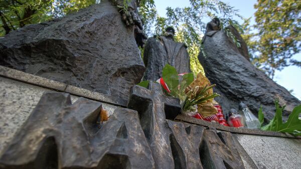 Flowers and candles rest on a memorial dedicated to the Katyn victims, to mark the 75th anniversary of the Soviet invasion of Poland at the start of WWII, in Katowice, Poland on September 17, 2014 - Sputnik International