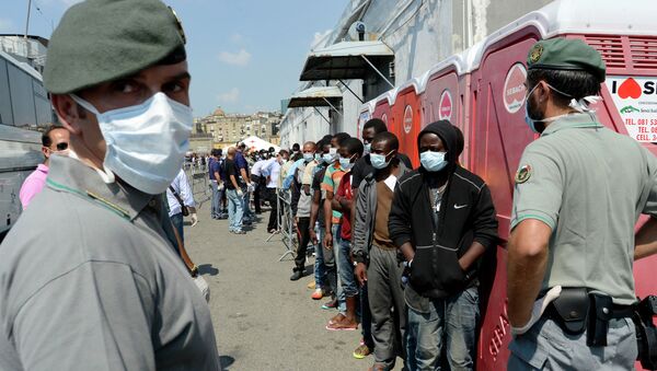 Men, part of a group of more than 330 migrants, stand in line after disembarking from the Italian Military ship Scirocco on August 30, 2014 in the port of Naples - Sputnik International