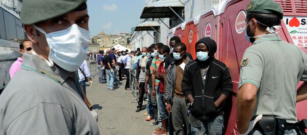 Men, part of a group of more than 330 migrants, stand in line after disembarking from the Italian Military ship Scirocco on August 30, 2014 in the port of Naples - Sputnik International