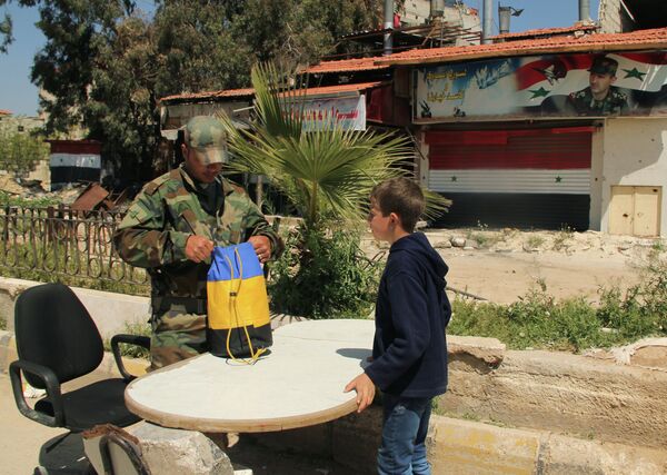 A Syrian serviceman checks documents and belongings of a refugee from the Yarmouk refugee camp on the outskirts of Damascus A Syrian serviceman checks documents and belongings of a refugee from the Yarmouk refugee camp on the outskirts of Damascus - Sputnik International