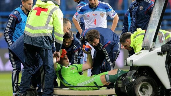 Medics evacuate Russian goalie Igor Akinfeyev from the pitch who was traumatized during the UEFA EURO 2016 qualifying match between the national teams of Montenegro and Russia - Sputnik International