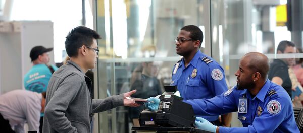 A traveler, left, hands his documents to a Transportation Security Administration officer as part of security screening at John F. Kennedy International Airport. A traveler, left, hands his documents to a Transportation Security Administration officer as part of security screening at John F. Kennedy International Airport. - Sputnik International