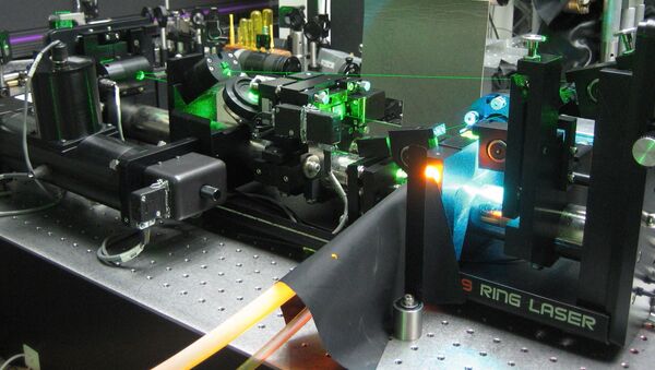 A Rhodamine laser dye (fluorescing orange) pumped with several Watts of Argon-ion laser radiation (bright blue) - Sputnik International