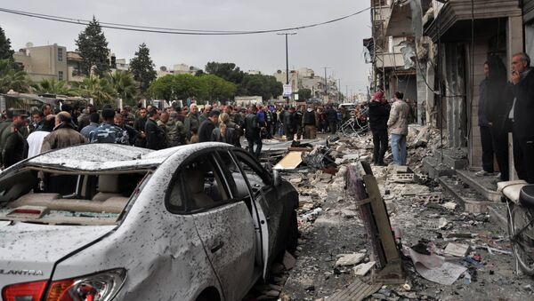 Syrian residents and security forces inspect the damage following a car bomb explosion on April 10, 2015, in the government-controlled majority Alawite neighbourhood of Hay al-Arman, located on the outskirts of the Zahraa district in Homs city - Sputnik International
