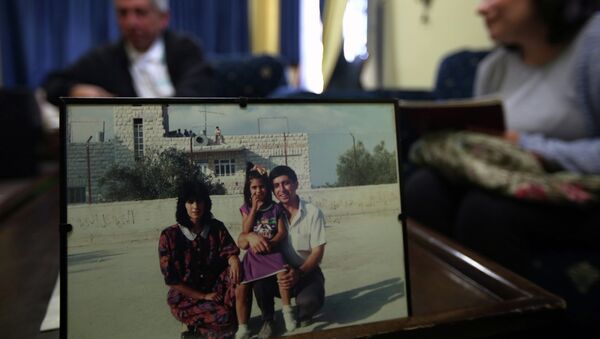 Ghassan Jarrar (background), the husband of Khalida Jarrar (portrait-L), a member of the Popular Front for the Liberation of Palestine (PFLP), sits behind a family picture on April 2, 2015 at their home in the West Bank city of Ramallah, where she was arrested the day before - Sputnik International