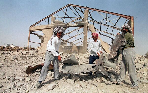 Iraqis clear away debris in front of a construction materials warehouse 12 August 2000, the morning after US and British warplanes bombed residential districts, a grain silo, the warehouse and the traffic department of the southern Iraqi city Samawa. (File) Iraqis clear away debris in front of a construction materials warehouse 12 August 2000, the morning after US and British warplanes bombed residential districts, a grain silo, the warehouse and the traffic department of the southern Iraqi city Samawa. (File) - Sputnik International