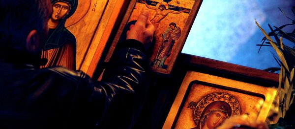 A man touches an icon with the crucifixion of Jesus Christ on Good Friday at St. Petka Orthodox church in Skopje, Macedonia A man touches an icon with the crucifixion of Jesus Christ on Good Friday at St. Petka Orthodox church in Skopje, Macedonia - Sputnik International