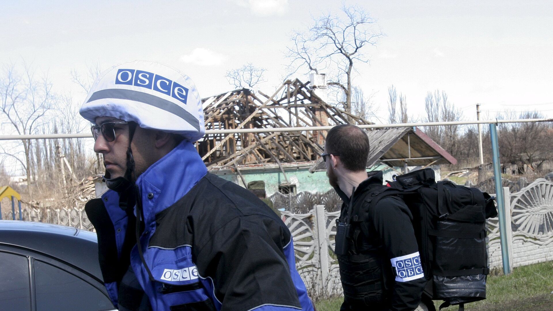 Members of the Special Monitoring Mission of the Organization for Security and Cooperation (OSCE) to Ukraine walk past a house damaged by shelling, in the village of Spartak outside Donetsk April 10, 2015 - Sputnik International, 1920, 13.02.2022