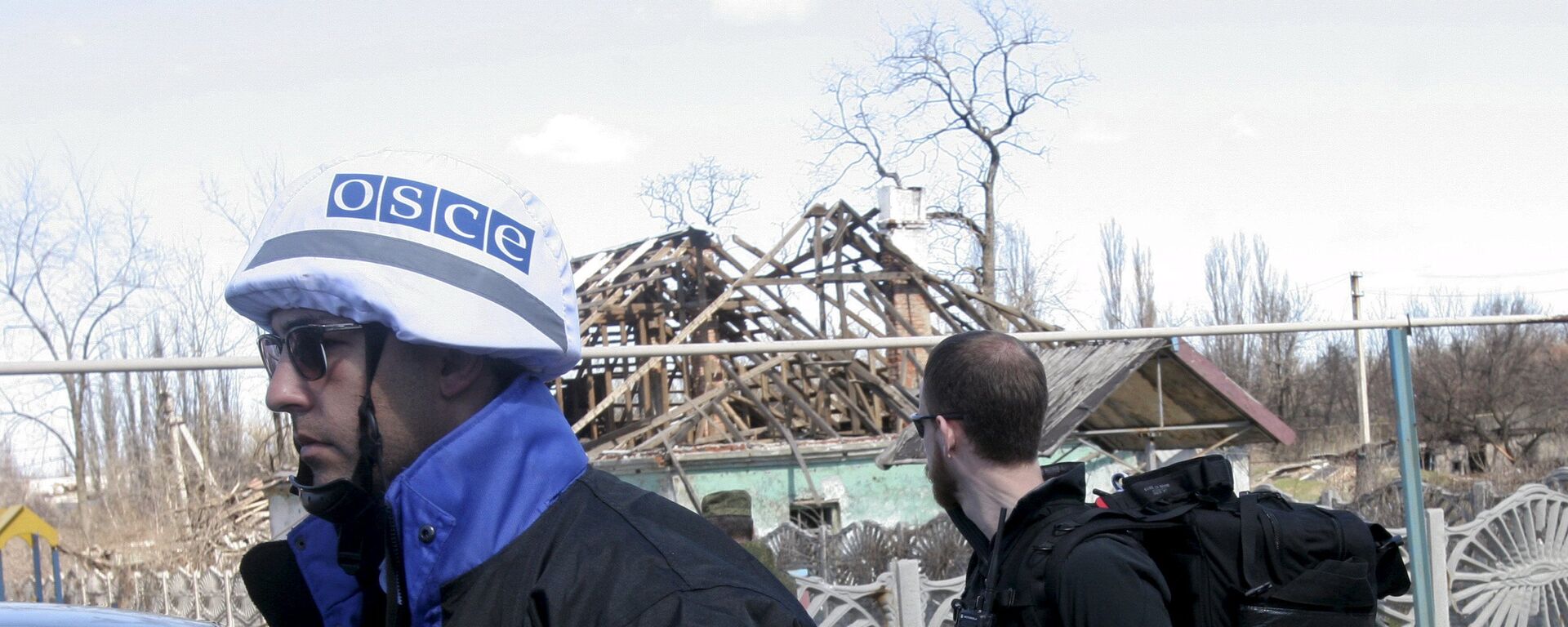 Members of the Special Monitoring Mission of the Organization for Security and Cooperation (OSCE) to Ukraine walk past a house damaged by shelling, in the village of Spartak outside Donetsk April 10, 2015 - Sputnik International, 1920, 13.02.2022