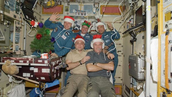 Wearing festive holiday hats, the Expedition 22 crew members are pictured while speaking with officials from Russia, Japan and the United States from the Zvezda Service Module of the International Space Station - Sputnik International