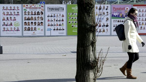 A woman walks past campaign posters of candidates in the Finnish Parliamentary elections put up along a street in Helsinki, April 10, 2015 - Sputnik International