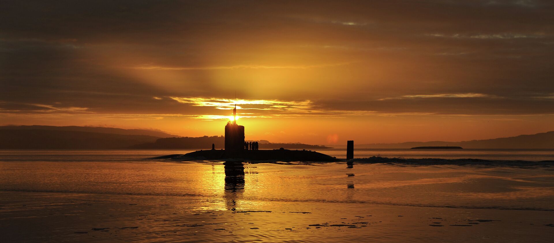 In this image made available by the Ministry of Defence in London, 18 October 2010, the sun rises over the Royal Navy nuclear attack submarine HMS Triumph, as she comes into a naval base on the River Clyde in Scotland - Sputnik International, 1920, 13.03.2021