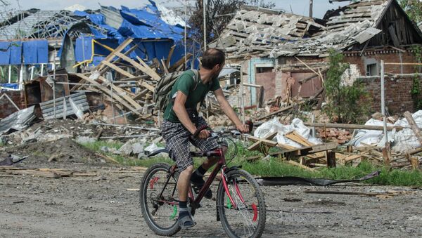 A local citizen rides a bicycle past destroyed houses after heavy fighting between independence supporters and Ukrainian government troops just outside Slavyansk, eastern Ukraine, Wednesday, July 9, 2014 - Sputnik International
