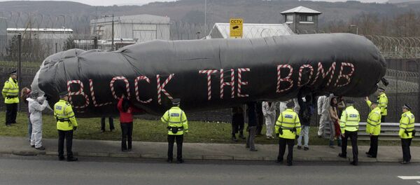 Campaigners hold an inflatable during a protest in front of the Trident submarine fleet naval base in Faslane, Scotland Campaigners hold an inflatable during a protest in front of the Trident submarine fleet naval base in Faslane, Scotland - Sputnik International