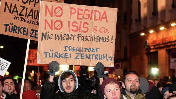 Counter-demonstrators hold up placards reading 'no Pegida, no ISIS and Fascism never again' as they protest against Duegida, a local copycat of Dresden's right-wing populist movement PEGIDA (Patriotic Europeans Against the Islamisation of the Occident) in Duesseldorf - Sputnik International