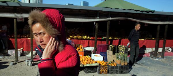 A woman walks past a shop selling fruits at an outdoor market in Beijing A woman walks past a shop selling fruits at an outdoor market in Beijing - Sputnik International