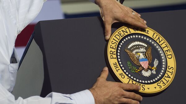 An aide places the Presidential seal on the podium prior to US President Barack Obama speaking during a campaign event at Kissimmee Civic Center in Kissimmee, Florida - Sputnik International
