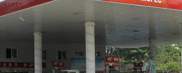 A man stands prepares to fill up his truck at a Sinopec's gas station in Beijing A man stands prepares to fill up his truck at a Sinopec's gas station in Beijing - Sputnik International