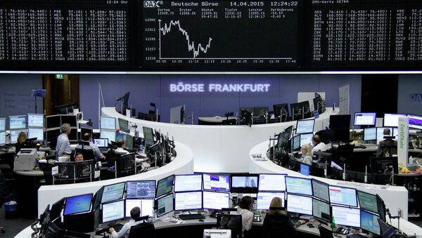 Traders are pictured at their desks in front of the DAX board at the Frankfurt stock exchange April 14, 2015 - Sputnik International