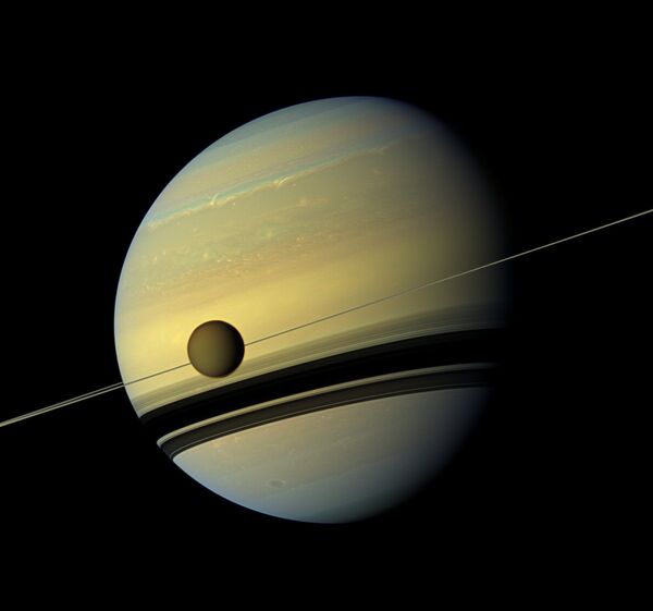 Saturn's largest moon Titan passing in front of the giant planet in an image made by NASA's Cassini spacecraft Saturn's largest moon Titan passing in front of the giant planet in an image made by NASA's Cassini spacecraft - Sputnik International