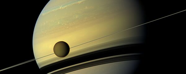 Saturn's largest moon Titan passing in front of the giant planet in an image made by NASA's Cassini spacecraft - Sputnik International