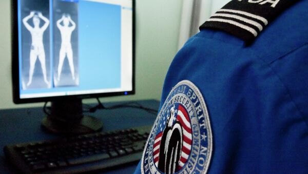 A TSA officer looks at a simulated image from a new backscatter X-ray machine  - Sputnik International