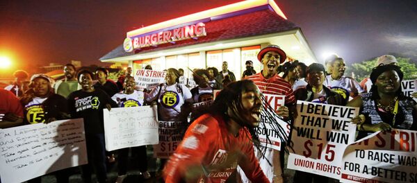 Joshua Collins, center, chants during a protest outside a Burger King restaurant by fast-food workers and activists calling for the federal minimum wage to be raised to $15, Wednesday, April 15, 2015, in College Park, Ga. Organizers say they chose April 15, tax day, to demonstrate because they want the public to know that many low-wage workers must rely on public assistance to make ends meet. - Sputnik International