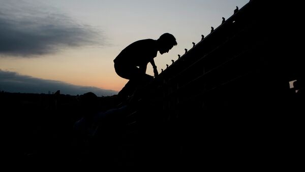 A migrant jumps to cross the U.S. Mexico border fence in Tijuana, Mexico, Thursday, Sept. 11, 2008. - Sputnik International