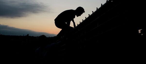 A migrant jumps to cross the U.S. Mexico border fence in Tijuana, Mexico, Thursday, Sept. 11, 2008. A migrant jumps to cross the U.S. Mexico border fence in Tijuana, Mexico, Thursday, Sept. 11, 2008. - Sputnik International