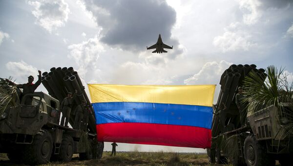 A Russian-made Sukhoi Su-30MKV fighter jet of the Venezuelan Air Force flies over a Venezuelan flag tied to missile launchers, during the Escudo Soberano 2015 (Sovereign Shield 2015) military exercise in San Carlos del Meta in the state of Apure - Sputnik International