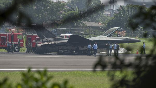 Air Force personnel stand near an Indonesian F-16 plane after it burned following an aborted take-off at Halim Air Base, East Jakarta April 16, 2015 - Sputnik International