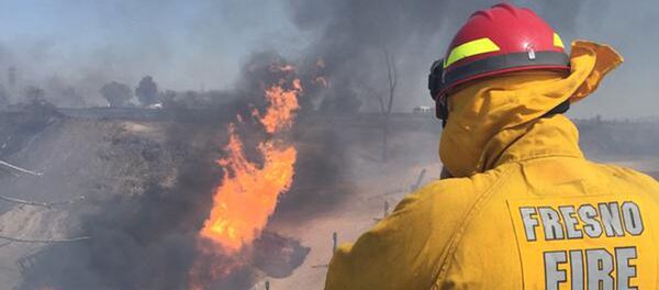 A firefighter watches the blaze after a gas line exploded near Fresno, California A firefighter watches the blaze after a gas line exploded near Fresno, California - Sputnik International